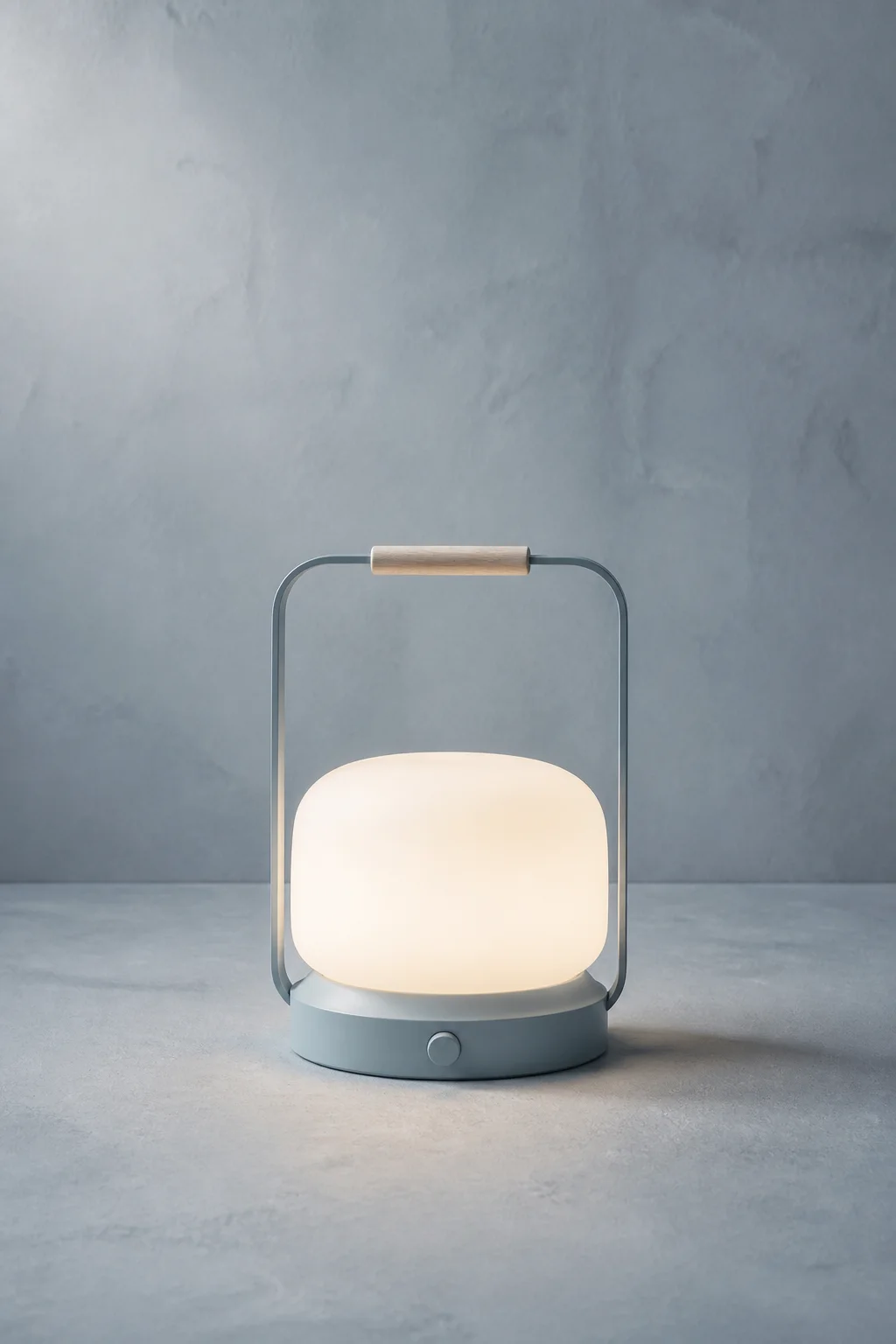 Halden Portable Lamp in Linen Blue with its opal-glass diffuser illuminated.